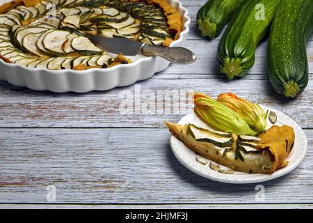 Fettine di una torta aperta di zucchine affettate in un formaggio farcito di fiori di zucchine Foto Stock