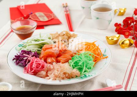 Yusheng, Yee Sang o Yuu Sahng, o Prosperity Toss è una insalata di pesce crudo in stile cantonese. Si compone di strisce di pesce crudo mescolato con verdure grattugiate Foto Stock