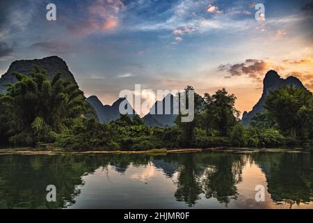 Tramonto colorato con riflessi nella zona del fiume li a Yangshuo, Guilin, Cina Foto Stock