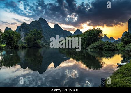 Tramonto estivo nella zona del fiume li con riflessi di alberi a Yangshuo, Guilin, Cina. Foto Stock