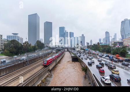 Tel Aviv, Israele - 28 gennaio 2022: Vista di un tradizionale treno rosso israeliano alla stazione ferroviaria di Tel Aviv Azrieli nella città di Tel Aviv. Traffico in una giornata piovosa. Foto di alta qualità Foto Stock