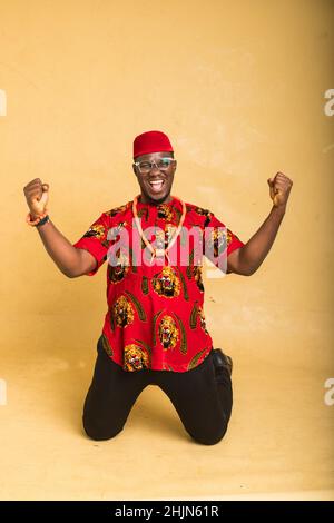 Igbo tradizionalmente vestito uomo d'affari che vince e festeggia Foto Stock