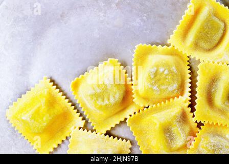 Ravioli quadrati non cotti su sfondo grigio Foto Stock