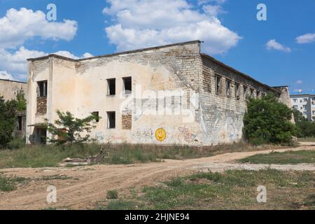 Un edificio fatiscente al crocevia delle strade di Kirova e Sadovaya nel villaggio di Uyutnoye, distretto di Saksky, Crimea, Russia Foto Stock