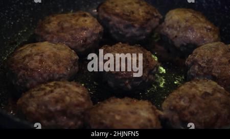 Primo piano di polpette di carne di maiale e manzo in una padella. Crocchette di carne rotonde e deliziose fritte in olio vegetale, cucina e concetto di cibo. Foto Stock