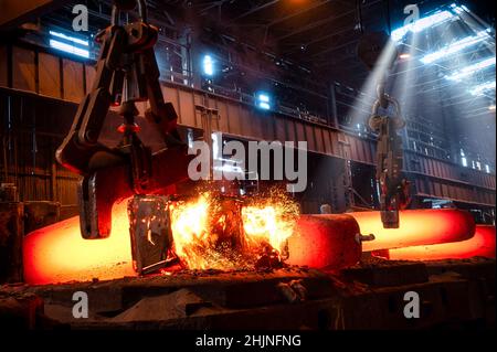 Il getto di metallo rosso-caldo viene trasportato da una gru metallurgica Foto Stock