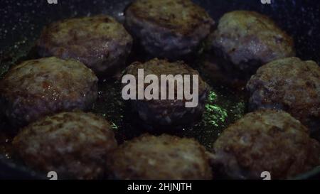 Primo piano di polpette di carne di maiale e manzo in una padella. Crocchette di carne rotonde e deliziose fritte in olio vegetale, cucina e concetto di cibo. Foto Stock