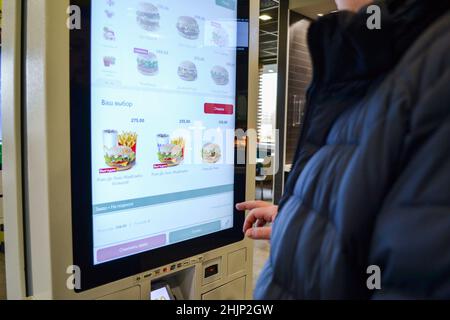 Mosca, Russia, novembre 2019: Un uomo seleziona gli hamburger presso un McDonald's utilizzando un terminale self-service. Foto Stock