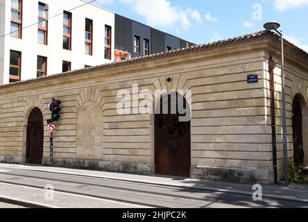 Piccoli edifici industriali o di stoccaggio del storey18th° secolo a Bordeaux, realizzati in pietra locale e splendidamente restaurati, con due moderne porte in acciaio Foto Stock