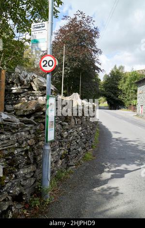 fermata dell'autobus e 20 mph segno sul lato del b5343 attraverso cappella style langdale valle, lake district, cumbria, inghilterra, regno unito Foto Stock