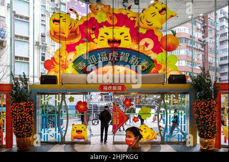 Hong Kong, Cina. 30th Jan 2022. Gli amanti dello shopping camminano davanti ad una esposizione decorativa a tema del centro commerciale Lunar di Capodanno cinese, durante i preparativi per il prossimo anno lunare della tigre cinese a Hong Kong. (Foto di Miguel candela/SOPA Images/Sipa USA) Credit: Sipa USA/Alamy Live News Foto Stock