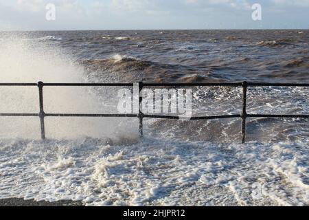 Onde che colpiscono le ringhiere a Crosby Beach a Liverpool, Merseyside, in una fredda mattinata di gennaio Foto Stock