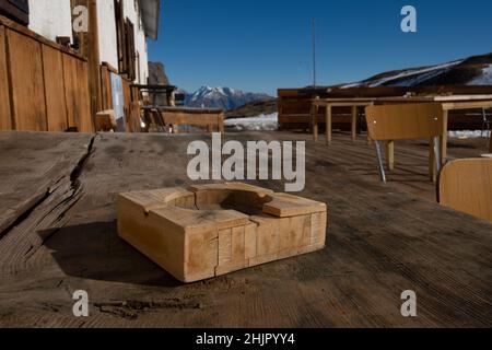 posacenere in legno leggero poggiato su un tavolo, presso il rifugio dondena in valle d'aosta, italia Foto Stock