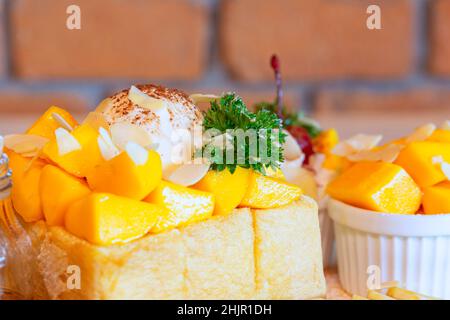 Toast al miele di Mango Tango, toast al miele con mango, gelato alla vaniglia e dessert alla panna montata. Foto Stock