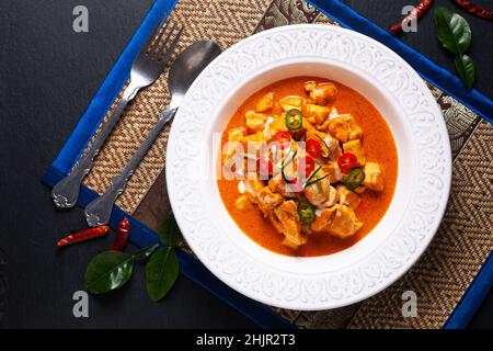 Thai Food Concept autentico pollo tailandese Panang Curry, Panang Kai in ciotola di ceramica su sfondo nero con spazio copia Foto Stock