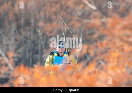 uomo che pesca da kayak in autunno Foto Stock