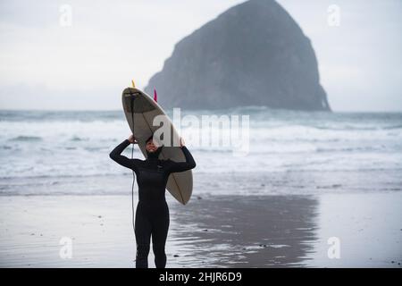 Surfista femminile divertirsi dopo aver preso le onde è Coastal Oregon Foto Stock