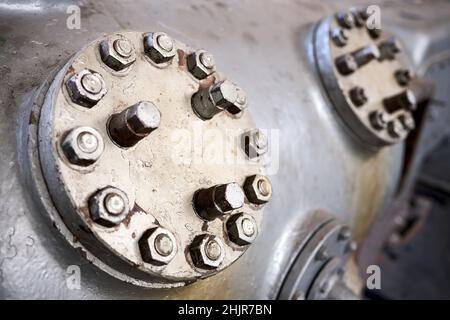 Due coperchi in metallo a vapore o botole piastra delle valvole del compressore in primo piano verniciata con vernice grigia imbullonata con viti prigioniere e dadi fondo con copyspace Foto Stock