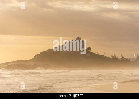 Splendida vista al tramonto dalla spiaggia tropicale di Itauna alla vecchia chiesa Foto Stock