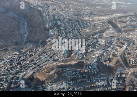 File di auto in piedi al mercato auto girato dall'alto. Vendita di auto usate portate dal Giappone. Foto Stock