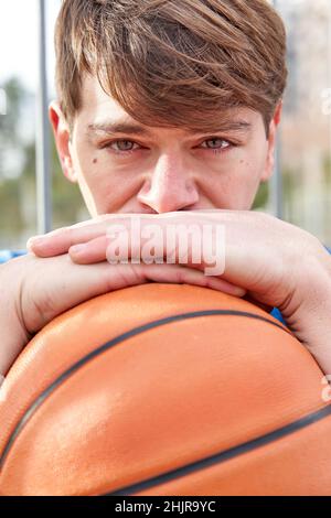 ritratto di un uomo che guarda la macchina fotografica con un basket in mano Foto Stock