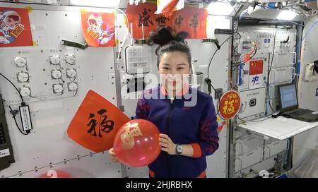 (220131) -- PECHINO, 31 gennaio 2022 (Xinhua) -- Taikonaut Wang Yaping, vestito in costumi festosi, desidera che i bambini attraverso la Cina 'vigorosa e sana crescita' mentre tiene un palloncino rosso, in uno screenshot ottenuto da un video. I membri dell'equipaggio di Shenzhen-13 sono diventati i primi cinesi a trascorrere il festival più importante della nazione -- il Capodanno lunare cinese -- nello spazio esterno. Credit: Xinhua/Alamy Live News Foto Stock