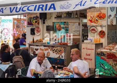 Palermo, Italia - Ottobre 23 2021: I locali mangiano frutti di mare in un ristorante dello storico mercato della Vucciria a Palermo, nella più grande città della Sicilia. T Foto Stock