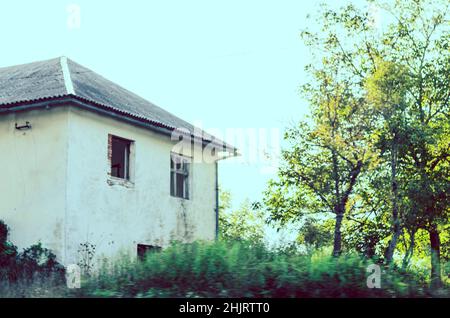 La Creepy House rimase danneggiata e abbandonata dopo la guerra civile in Croazia. Natura selvaggia con alberi e cespugli circonda il Cottage. Foto Stock