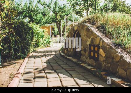 Casa decorativa in giardino. Percorso nel giardino Foto Stock