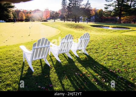 Tre sedie Adirondack su un campo da golf Country Club Foto Stock