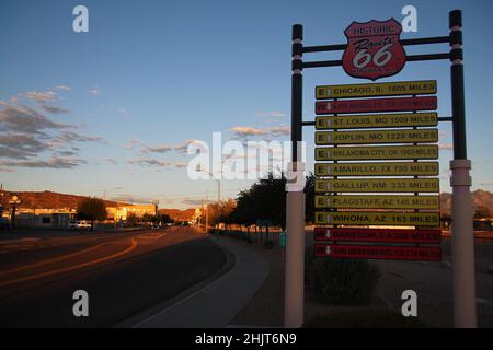 Il cartello stradale con tutte le destinazioni in un tramonto arancione a Kingman in Arizona Foto Stock