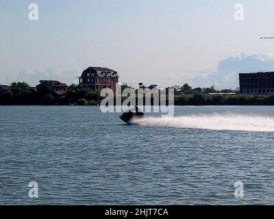 Uno scooter d'acqua sul fiume. Un uomo guida una moto d'acqua. Foto Stock