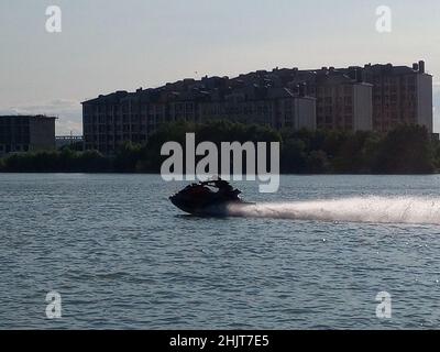 Uno scooter d'acqua sul fiume. Un uomo guida una moto d'acqua. Foto Stock