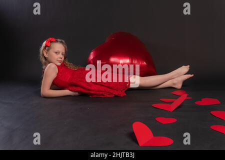 La ragazza si trova felice con un grande cuore di San Valentino capretto nero ornamento giorno, da stampa casuale in forma da illustrazione trendy, decorativo modello. R Foto Stock