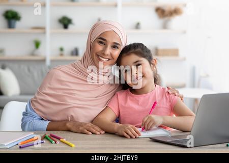 Home Ritratto della donna musulmana felice a Hijab e sua figlia piccola Foto Stock