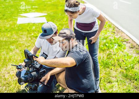 Un cameraman operatore discutere il processo di ripresa con un direttore e DP Foto Stock