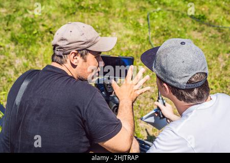 Un cameraman operatore discutere il processo di ripresa con un direttore e DP Foto Stock