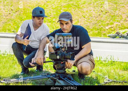 Un cameraman operatore discutere il processo di ripresa con un direttore e DP Foto Stock