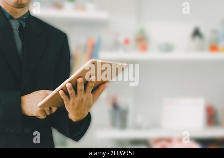 uomo d'affari che tiene un tablet per cercare informazioni e fare affari online. Foto Stock