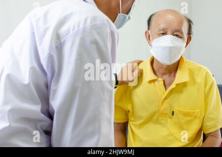 il medico tenne la spalla e parlò con un anziano malato per dare incoraggiamento. Foto Stock