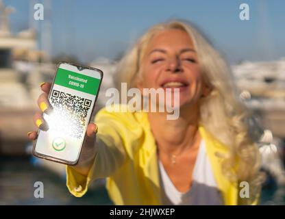 Le donne mostrano passaporto sanitario di certificato di convivio al telefono Foto Stock