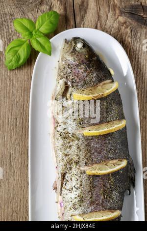 Trota iridea al forno con limone. Piatto per la cena Foto Stock