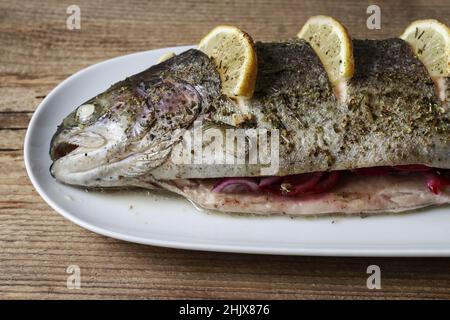 Trota iridea al forno con limone. Piatto per la cena Foto Stock