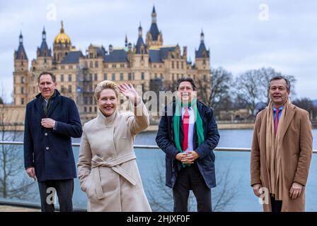 01 febbraio 2022, Meclemburgo-Pomerania occidentale, Schwerin: Manuela Schwesig (SPD, 2nd da sinistra), Ministro-Presidente del Meclemburgo-Pomerania occidentale, ondeggia durante un'occasione fotografica di fronte al castello con Heiko Miraß (SPD, l), Segretario di Stato parlamentare della Pomerania occidentale e del Meclemburgo orientale, Reinhard Meyer (SPD, 2nd da.r), Ministro dell'economia, del turismo e dei trasporti di Meclemburgo-Pomerania occidentale E Heiko Geue (SPD, r), Ministro delle Finanze del Meclemburgo-Pomerania occidentale, ad un dipendente prima dell'inizio della riunione annuale di avvio del governo statale del Meclemburgo-Pomerania occidentale Foto Stock