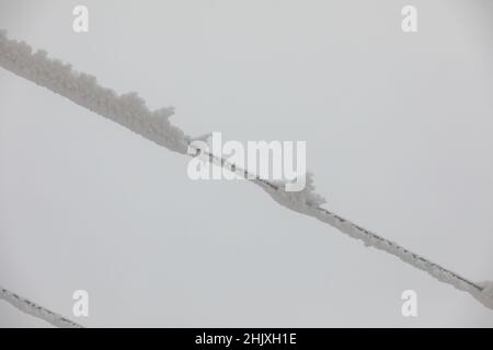 Piloni della linea di alimentazione congelati. Gelo su cavi e tralicci ad alta tensione. Inverno in montagna. Foto Stock