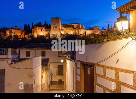 GRANADA ANDALUCIA SPAGNA ALHAMBRA PALACE VISTA DA UNA STRADA NEL CENTRO STORICO DI NOTTE Foto Stock