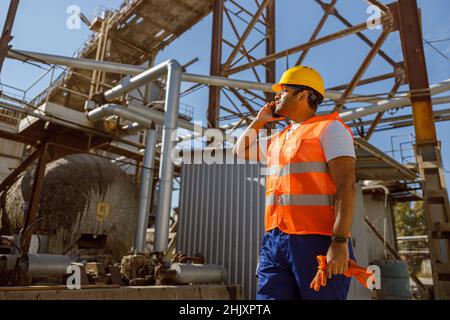 Abile ingegnere multietnico che lavora presso impianti industriali pesanti Foto Stock