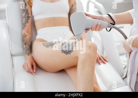 Cosmetologo che esegue la procedura di rimozione dei capelli laser in salone di bellezza Foto Stock