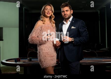 Gioco di poker vincente per uomo e ragazza vicino al tavolo da gioco nel casinò Foto Stock