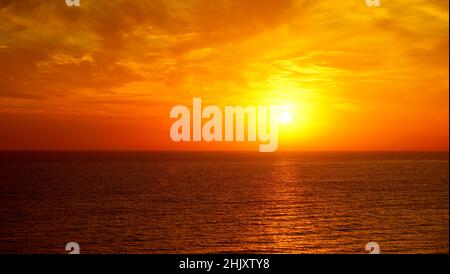 Fantastico oceano e cielo tramonto in colori rosso brillante. Foto Stock